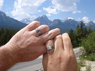 Our couple's hands showing their rings and the Canadian Rockies in the background