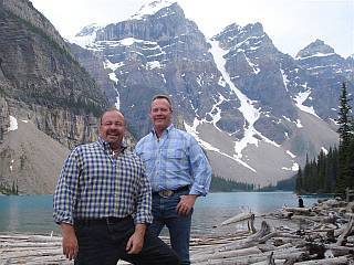 Don and James with a lake and snow capted mountains in background